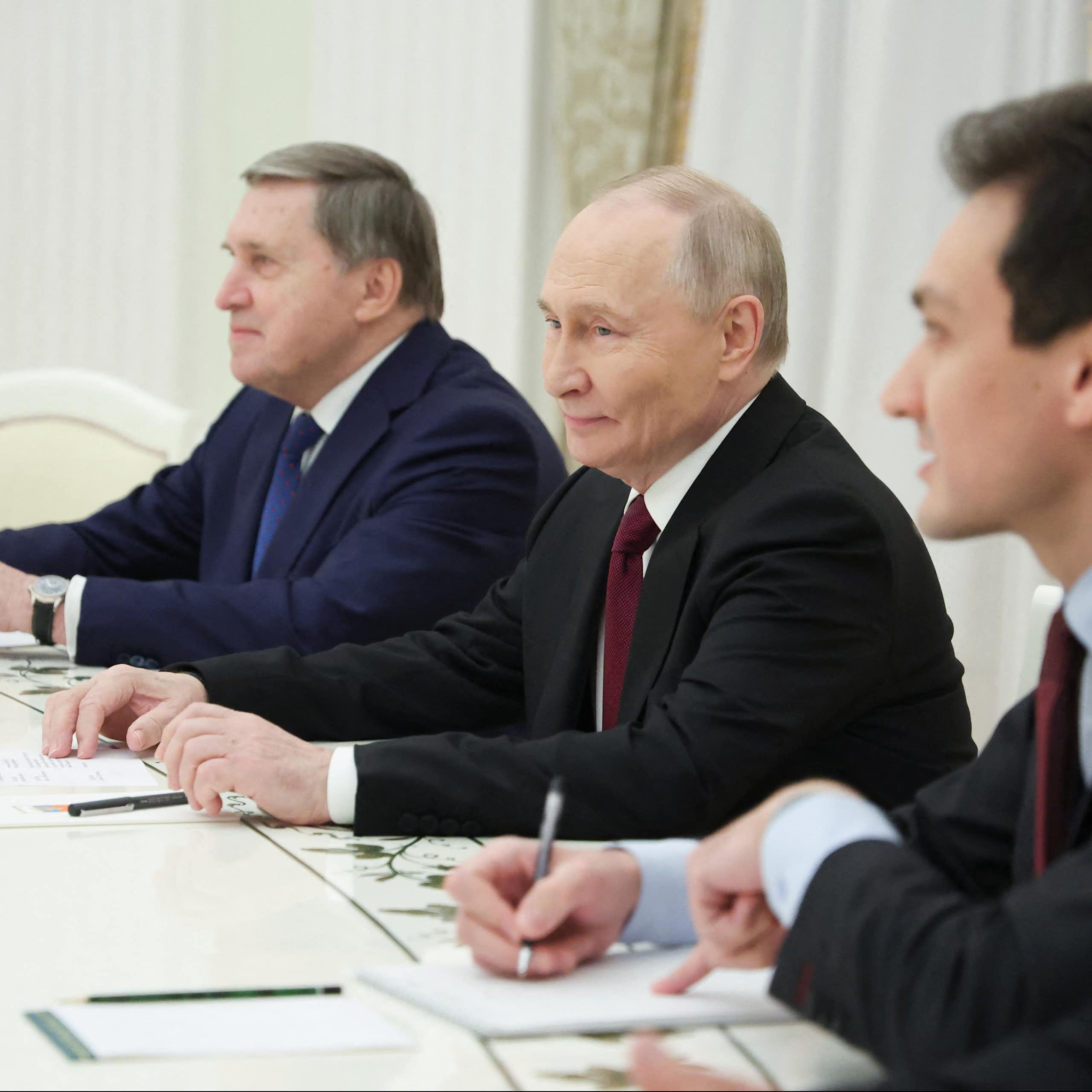 Men in suits sit at a table.