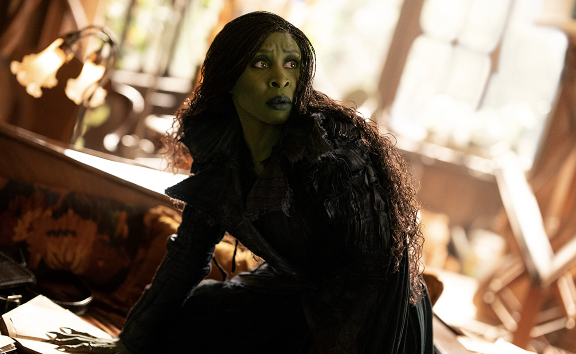 A picture of the actress Cynthia Erivo made up with green skin as the wicked witch Elphaba in the film Wicked: For Good.