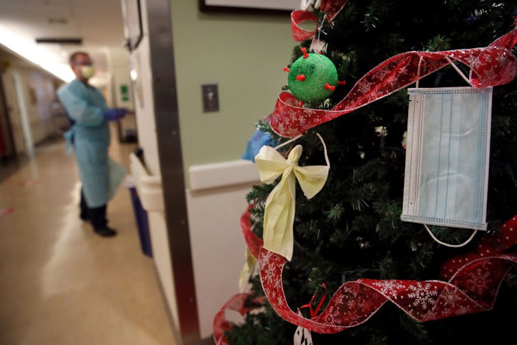 Merry Jewish Christmas: How Chinese language meals and the films turned into a time-honored custom for American Jews 2 A man in blue protective equipment enters a room off of a corridor with a Christmas tree decorated in red ribbon, homemade ornaments, and a medical mask.