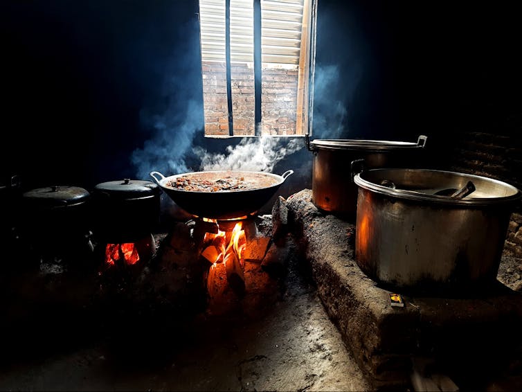 Kitchen with wood-fired stove creating white smoke