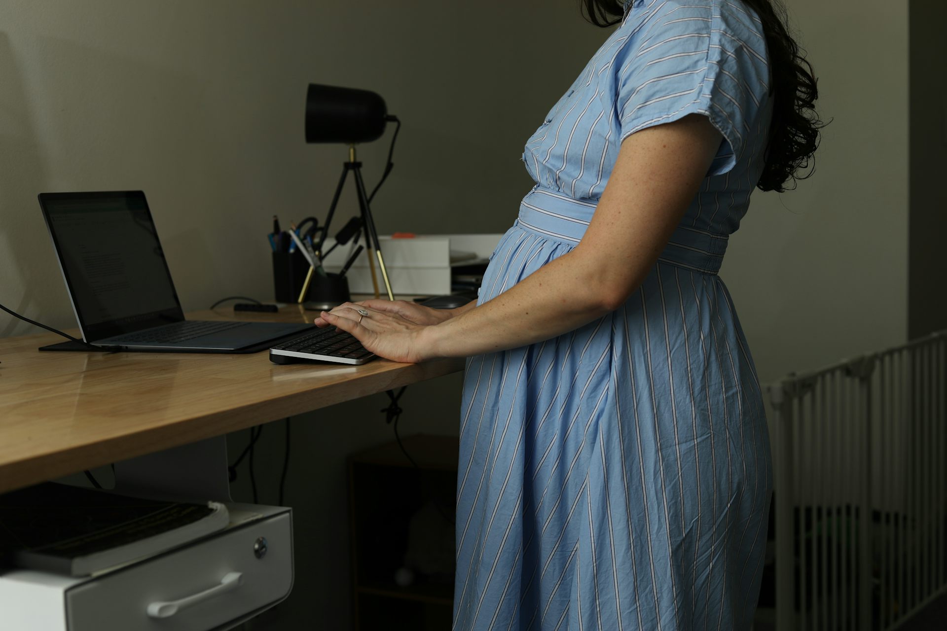 A pregnant woman working at a computer.