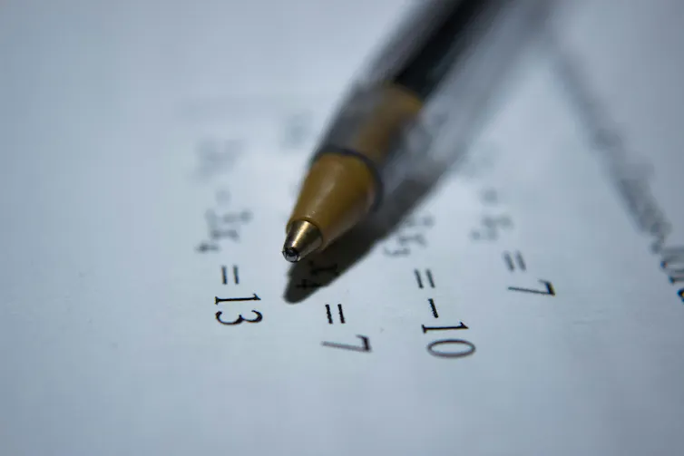 Un crayon sur une feuille de papier montrant des équations mathématiques