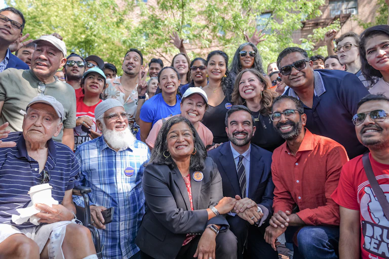 A crowd of smiling people, outside.