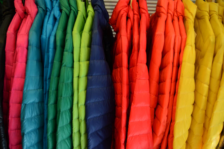 A rack full of brightly colored winter jackets.