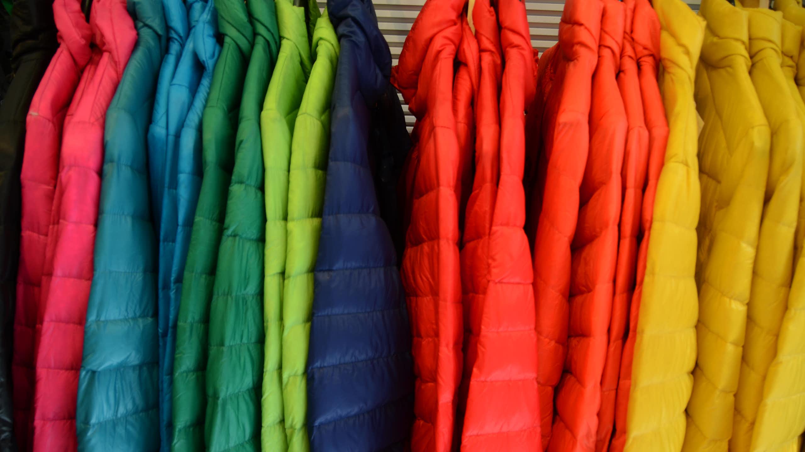 A rack full of brightly colored winter jackets.