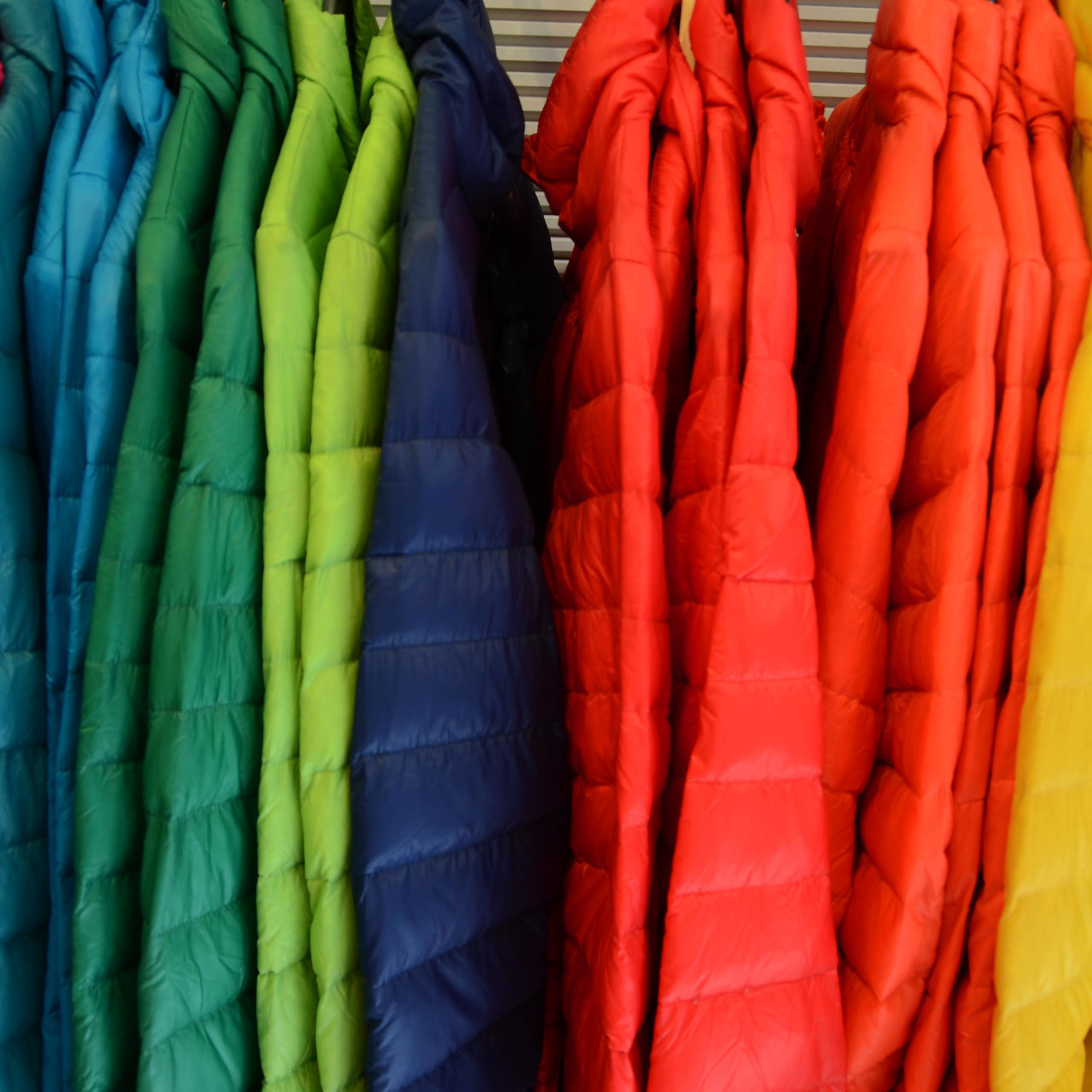 A rack full of brightly colored winter jackets.