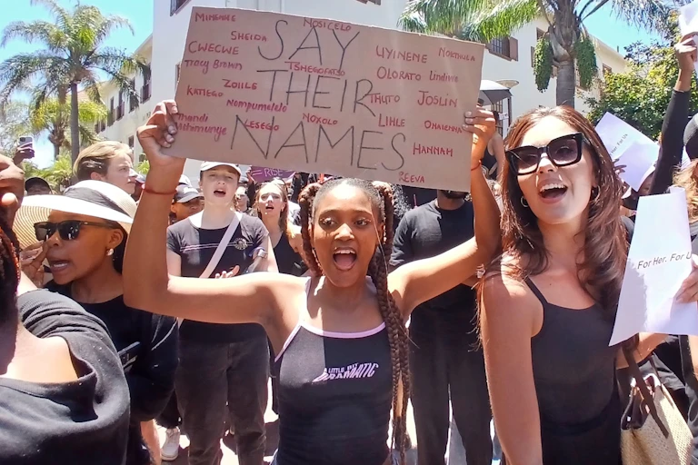 Women protest with a placard that says 'Say their Names' bearing names of victims of femicide