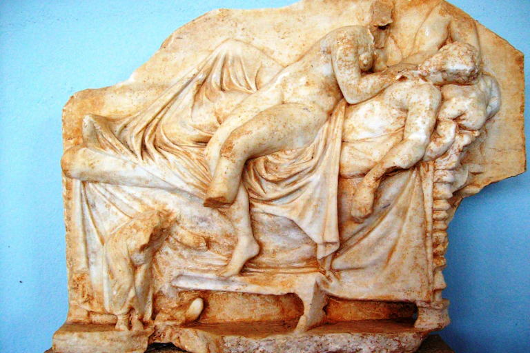 Marble anaglyph of ancient symposium. A couple in love time.