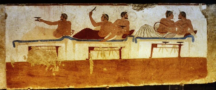 Men lying down at a symposium (party) in ancient Greece
