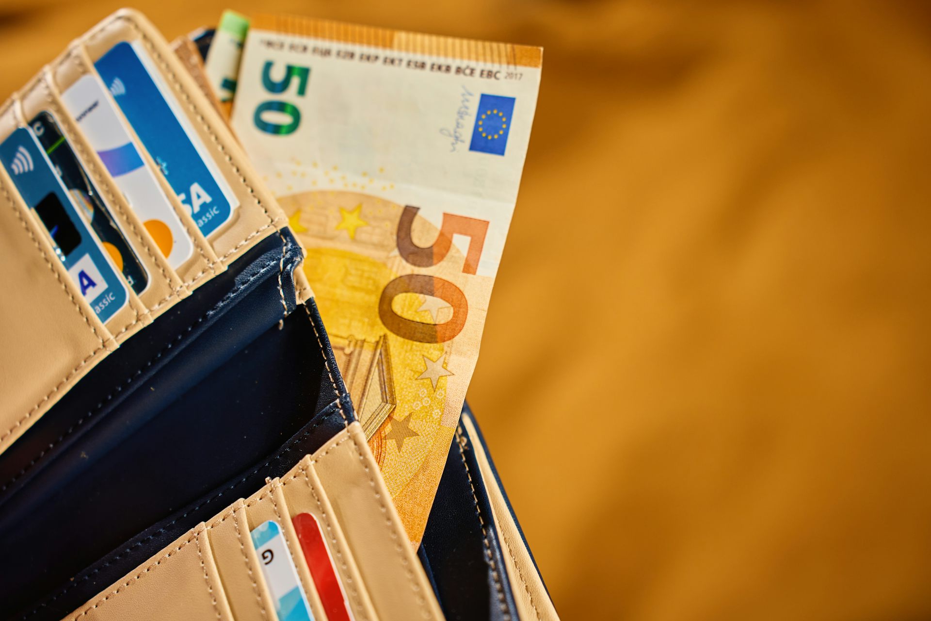 Une portefeuille avec des billets de banques et plusieurs cartes de crédit.