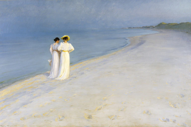Two women walking down a beach arm in arm