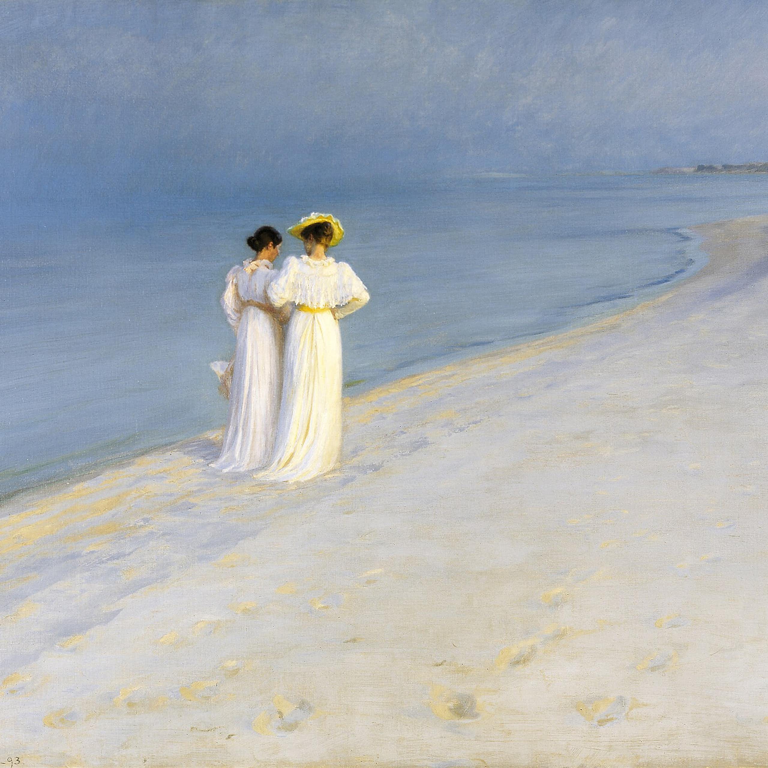 Two women walking down a beach arm in arm