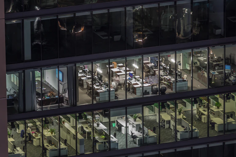 Vue d'un espace de co-working dans une tour de nuit.