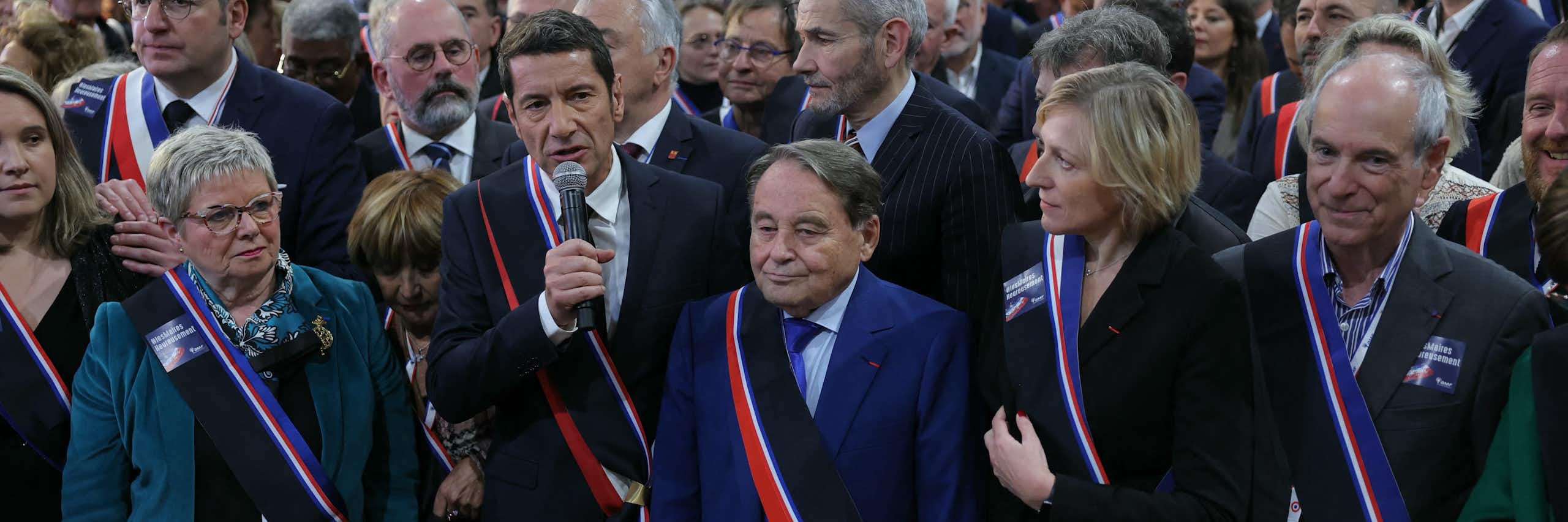 Au micro David Lisnard, président de l'association des maires de France, au centre Andre Laignel, vice-president et à droite Murielle Fabre, secrétaire générale, entourés d'autres élus lors du Congrès des maires en 2024