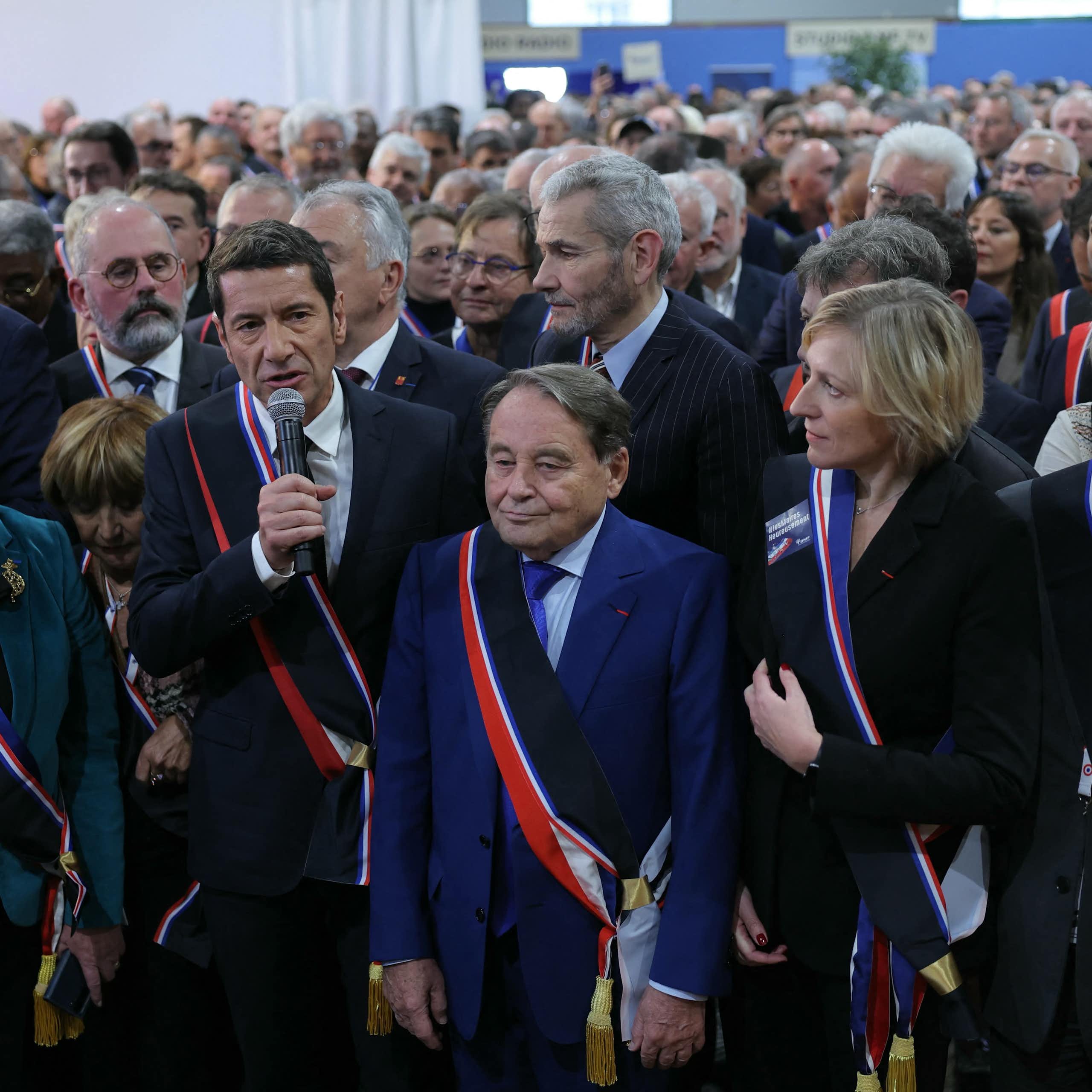 Au micro David Lisnard, président de l'association des maires de France, au centre Andre Laignel, vice-president et à droite Murielle Fabre, secrétaire générale, entourés d'autres élus lors du Congrès des maires en 2024