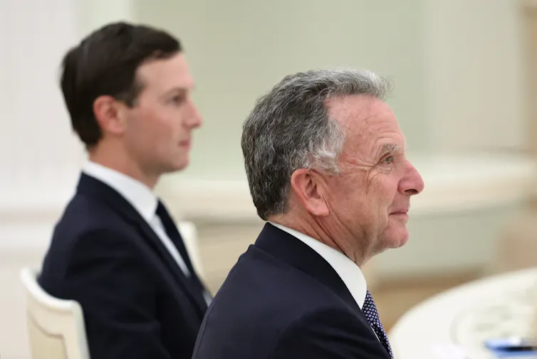 An older man and a younger dark-haired man photographed in profile.