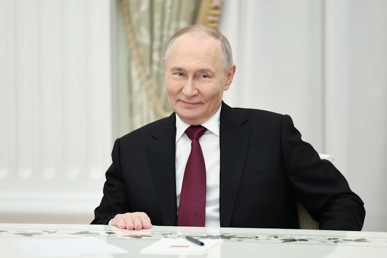 The Russian president Vladimir Putin, sits at his table.