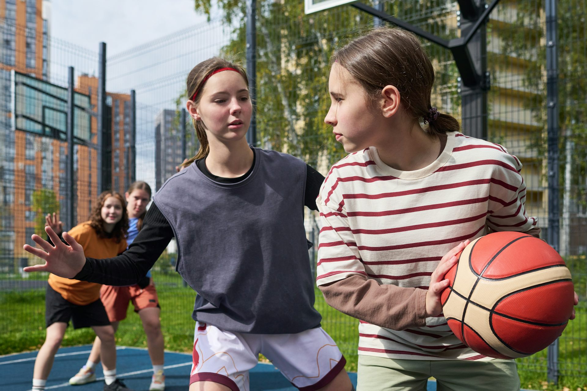 Dos adolescentes jugando al baloncesto.