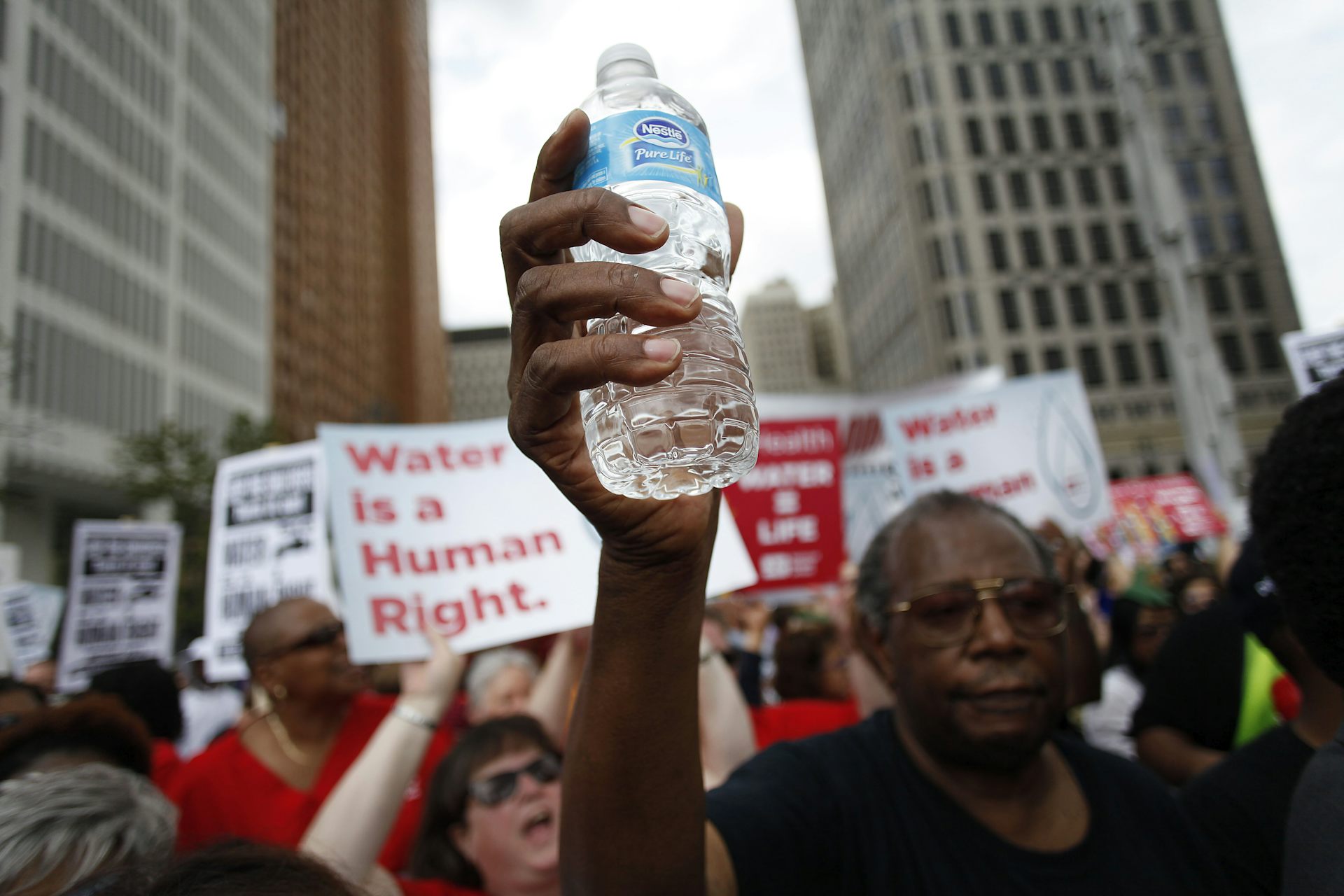 Man holds up water bottle.