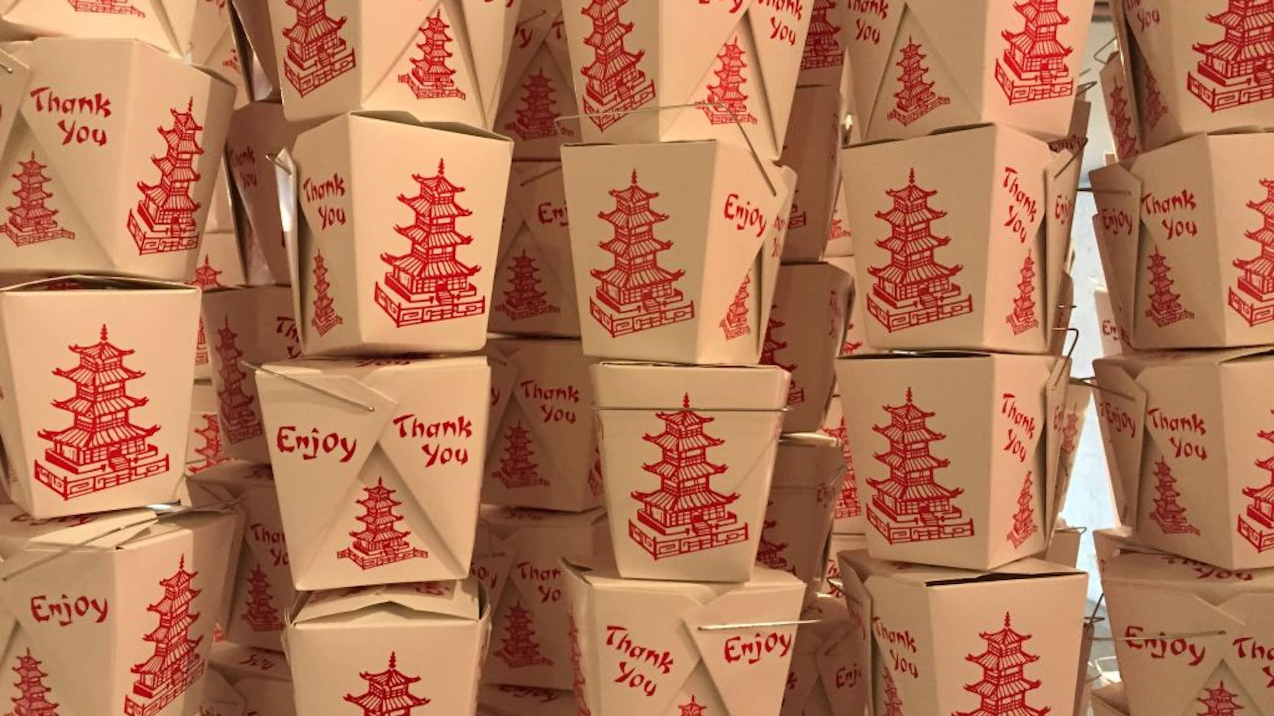 Stacks of white take-out food containers with pictures of red pagodas on them.