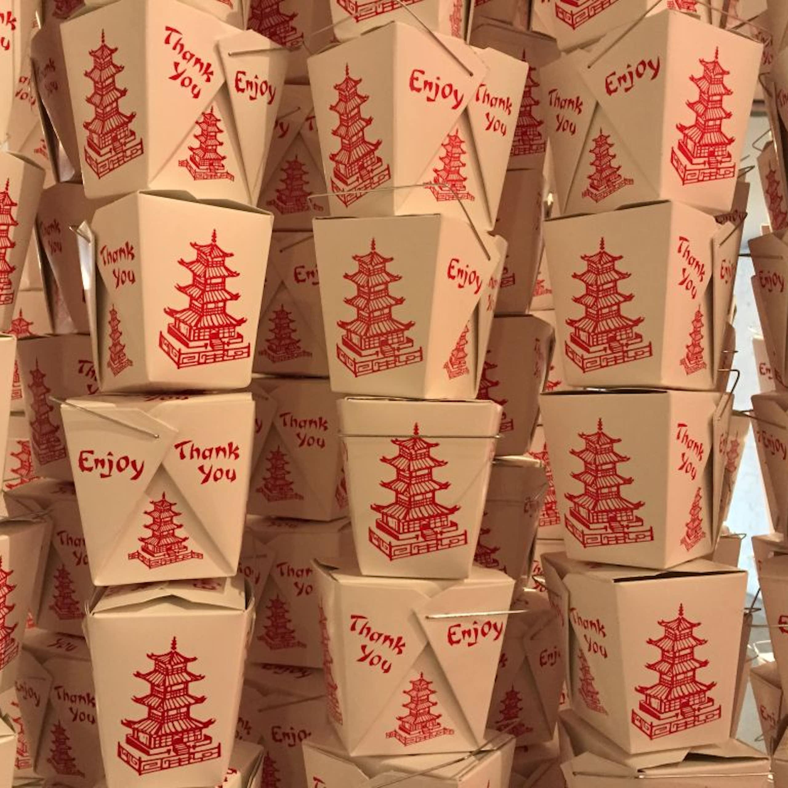 Stacks of white take-out food containers with pictures of red pagodas on them.