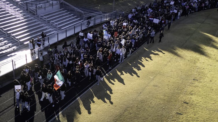 Younger, undocumented immigrants are discovering it more and more onerous to wait faculty as South Carolina and different states prohibit in-state tuition or ban them altogether 1 An aerial view shows a large group of people walking together on a track.