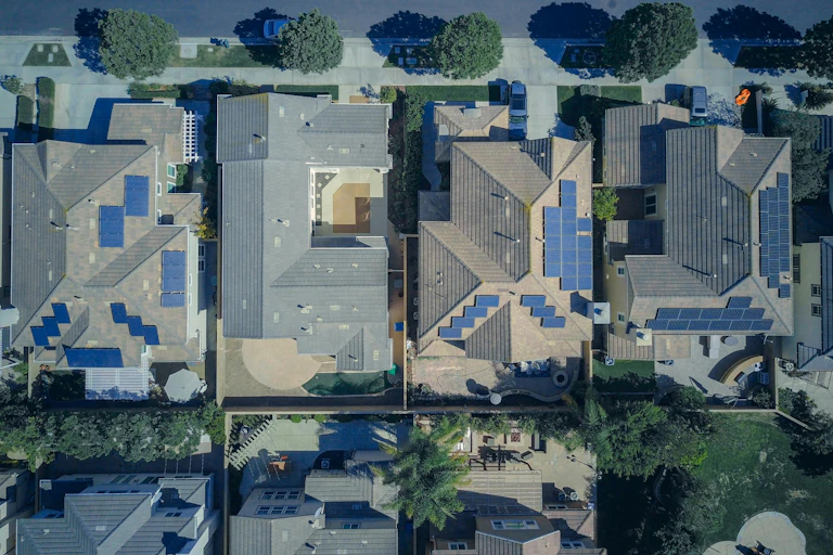 An aerial view of large houses with solar panels.