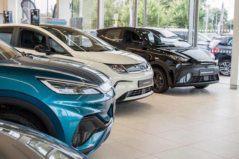 new electric cars on display inside a dealership.