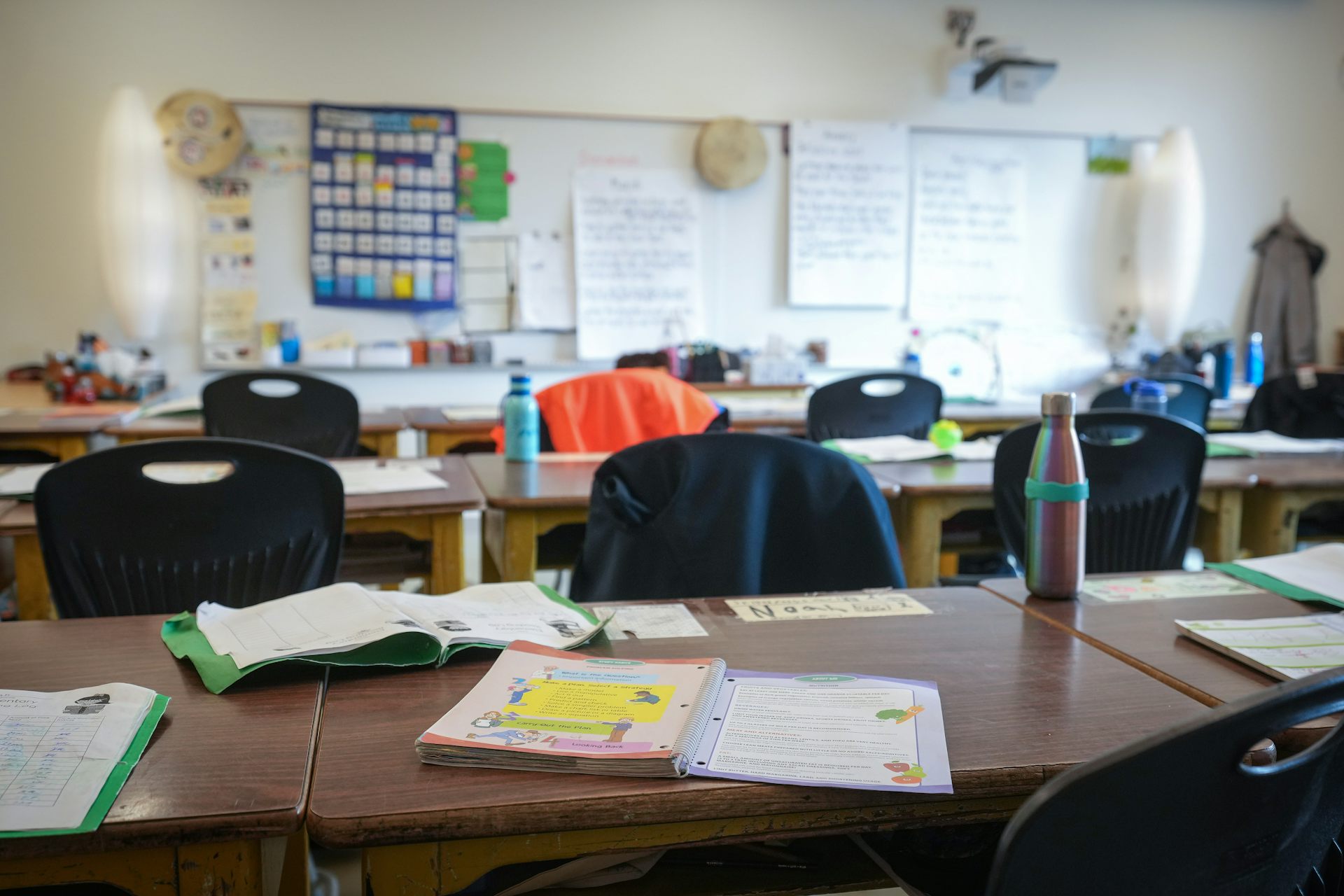 A workbook seen on a desk in a classroom.