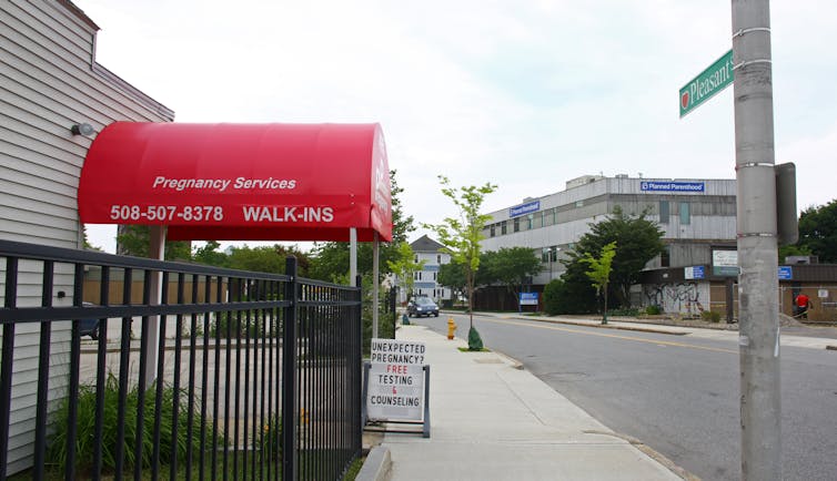 Photo of a storefront location for a place called Problem Pregnancy with a sign outside offering 'free testing and counseling.'