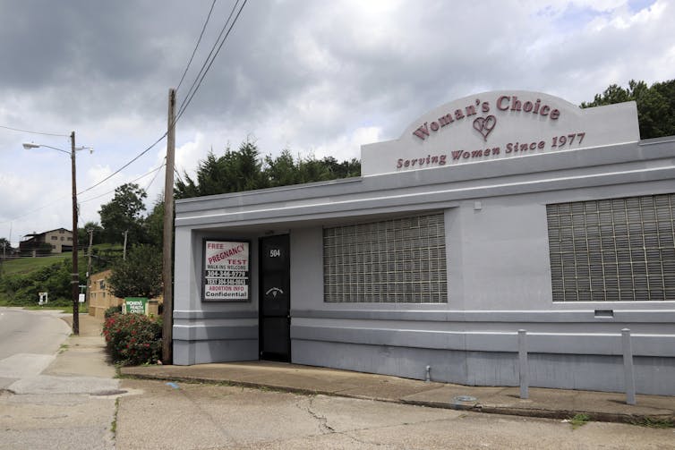 A sign advertises free pregnancy tests and abortion information outside a building identified as the Woman's Choice Pregnancy Resource Center.