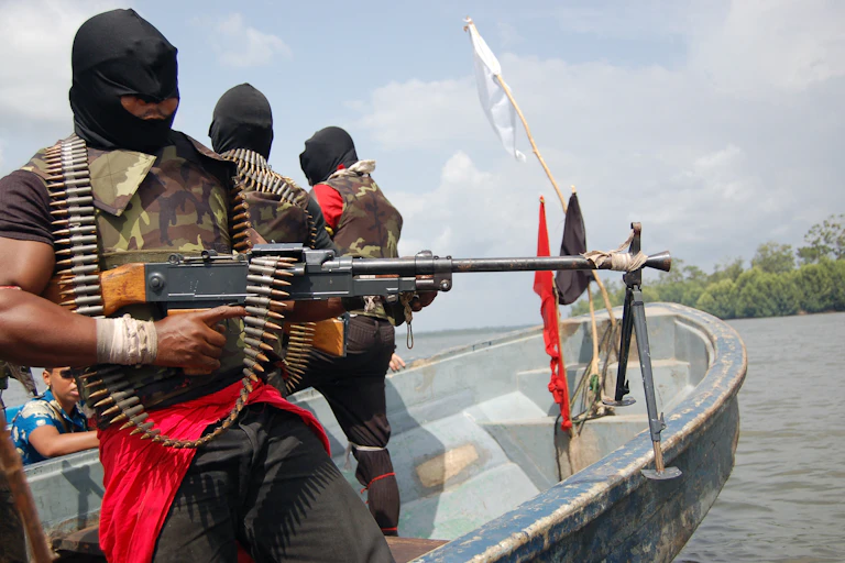 Men displaying weapons while standing on a boat