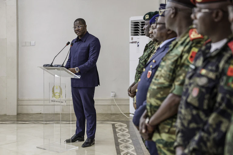 A man standing at a podium in front of military officers