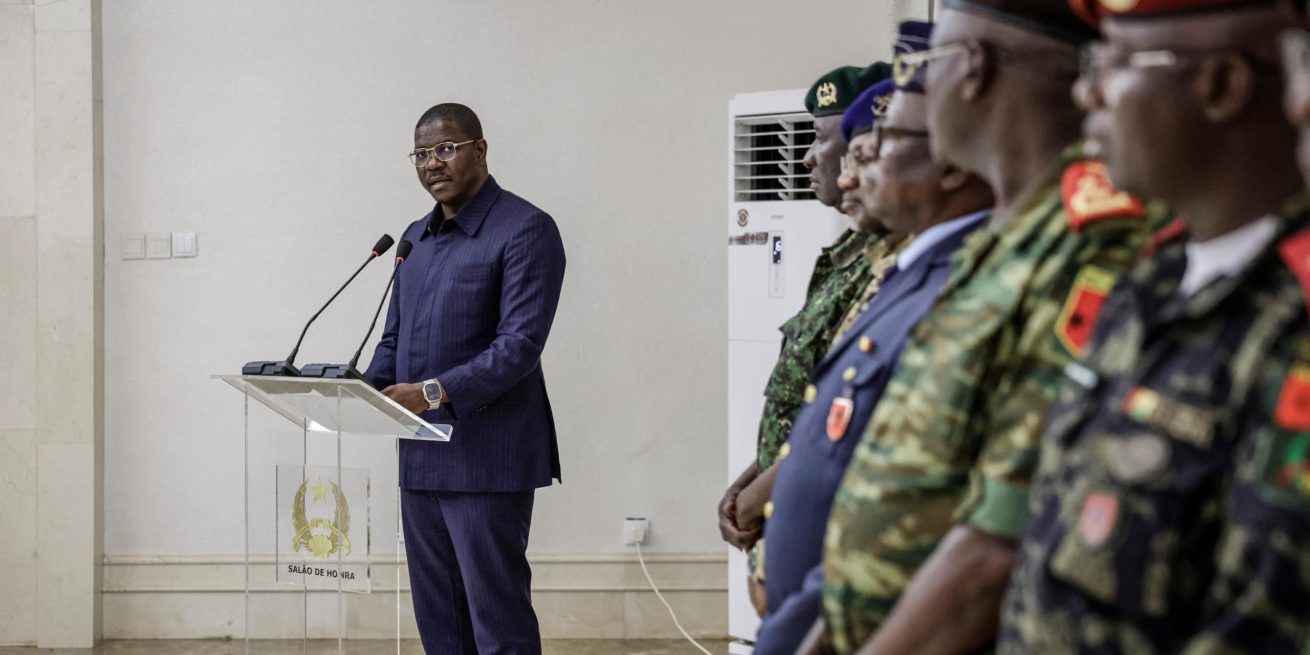 A man standing at a podium in front of military officers