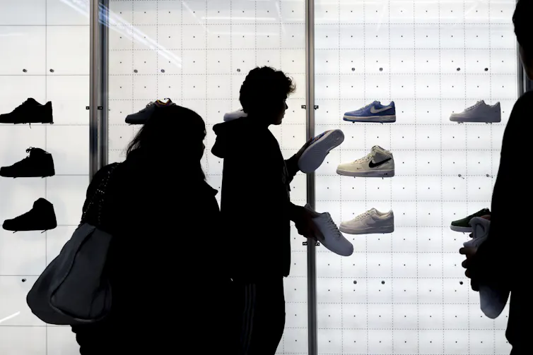 Silhouette of people browsing for shoes in a shoe store