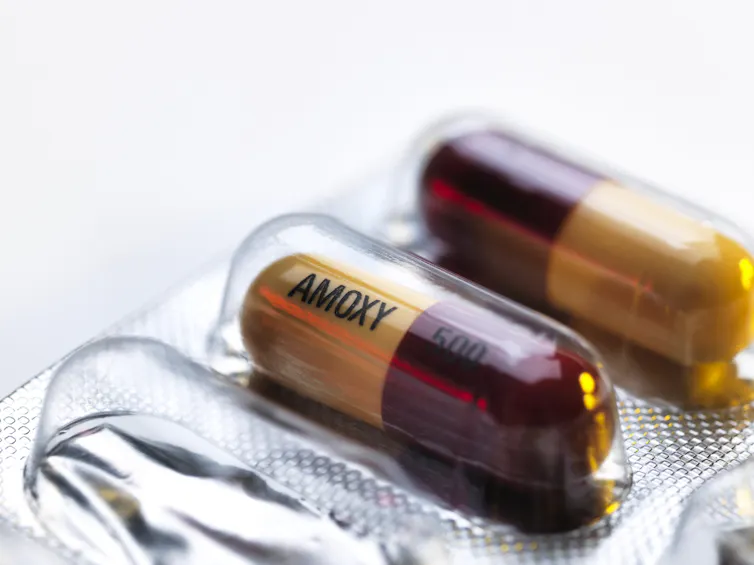 Close-up of two pill capsules inscribed AOMXY 500 in a blister packet
