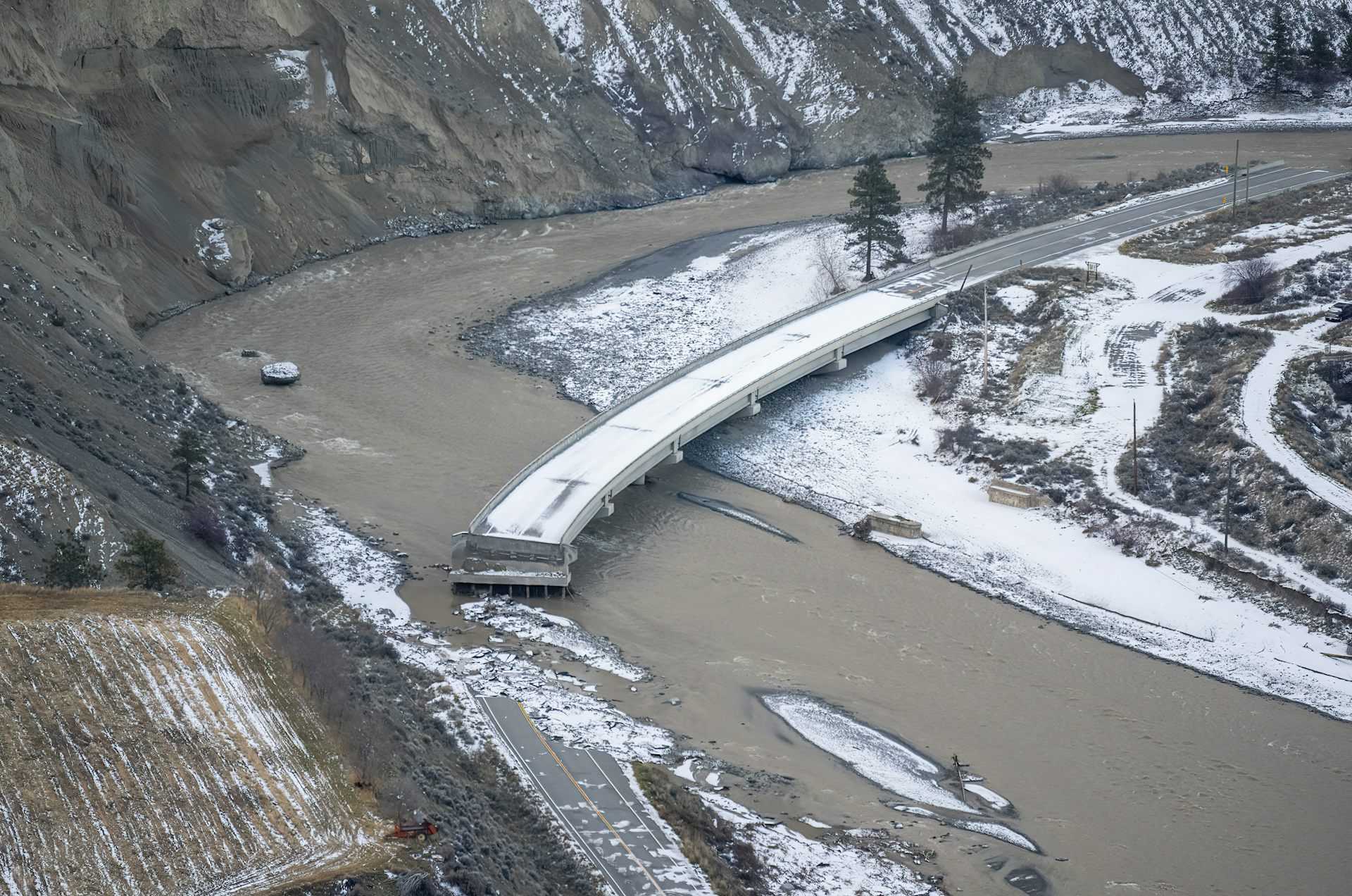 A washed-out bridge in a snowy valley.