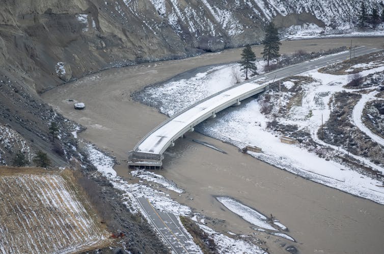Un puente arrasado en un valle nevado.