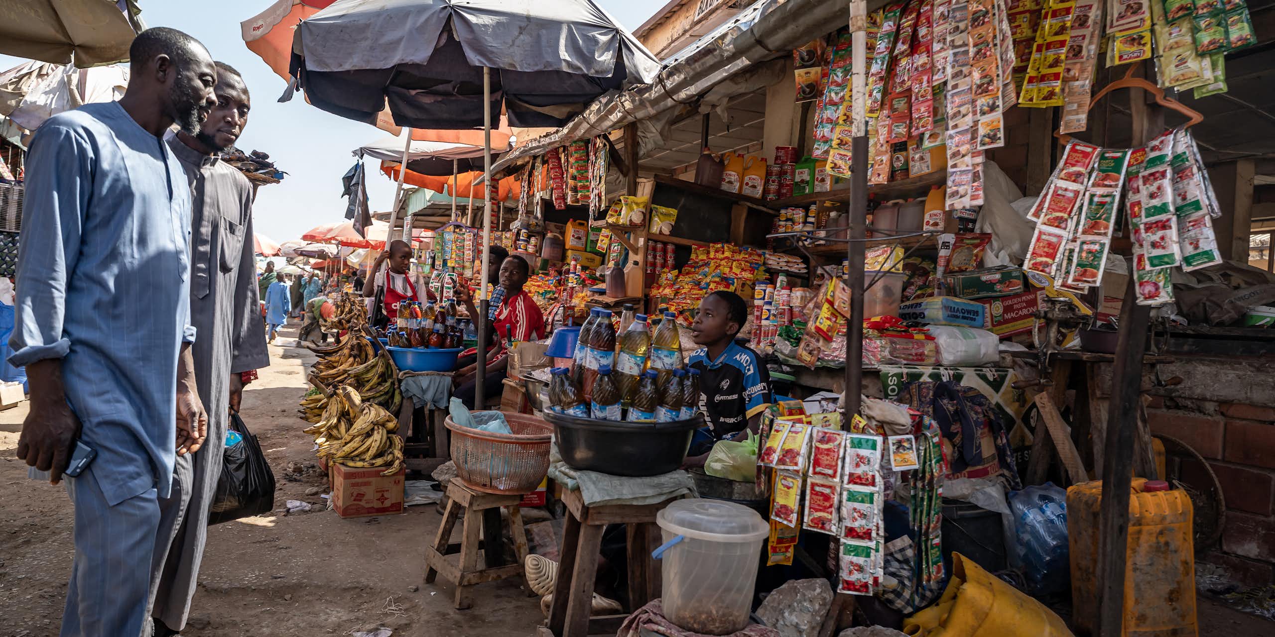 Two men looking at displays of goods at an informal market