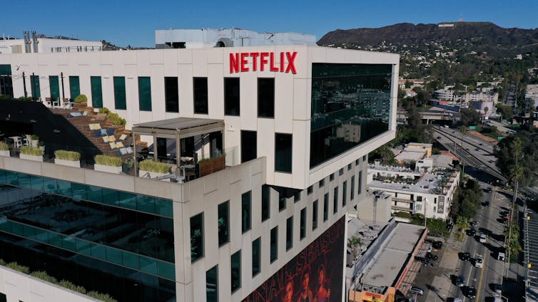 Netflix and Warner Bros. logos side by side, symbolizing the major streaming industry merger and the emergence of a dominant “Big Three” in digital entertainment.