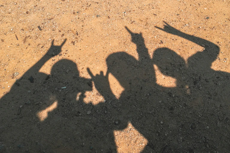Silhouette of kids posing for a photo on a beach.
