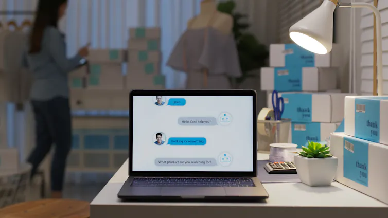 laptop on a desk with a chatbot conversation showing on the screen.