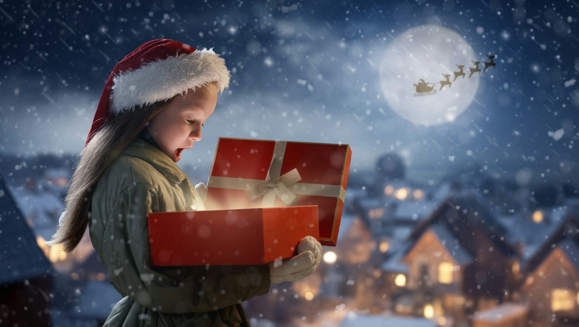 Une petite fille ouvre un cadeau déposé par le traîneau du Père Noël