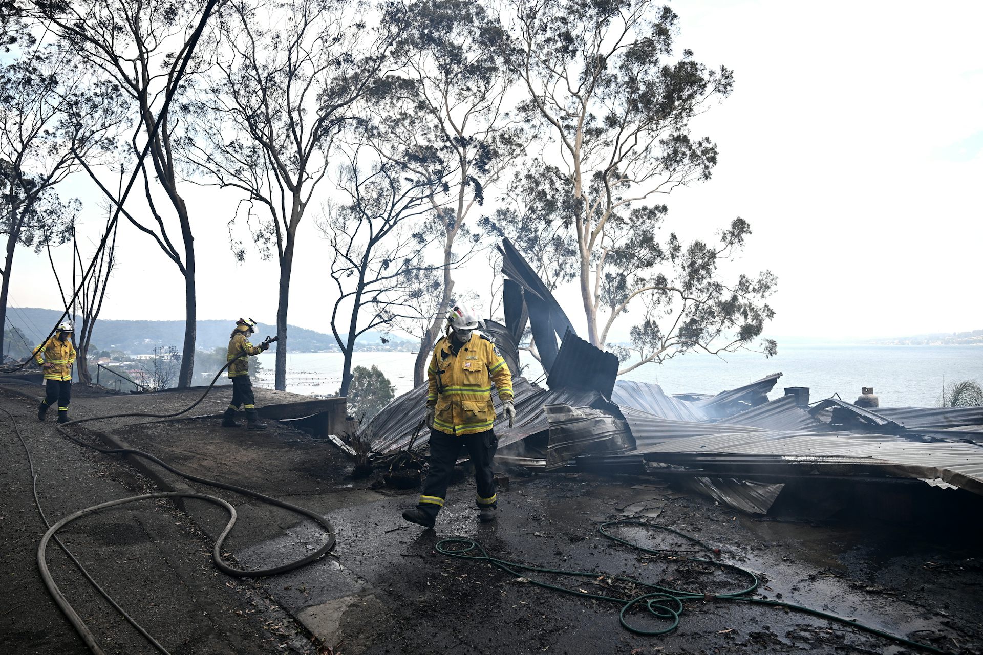 firefighters mopping up after bushfire destroyed house