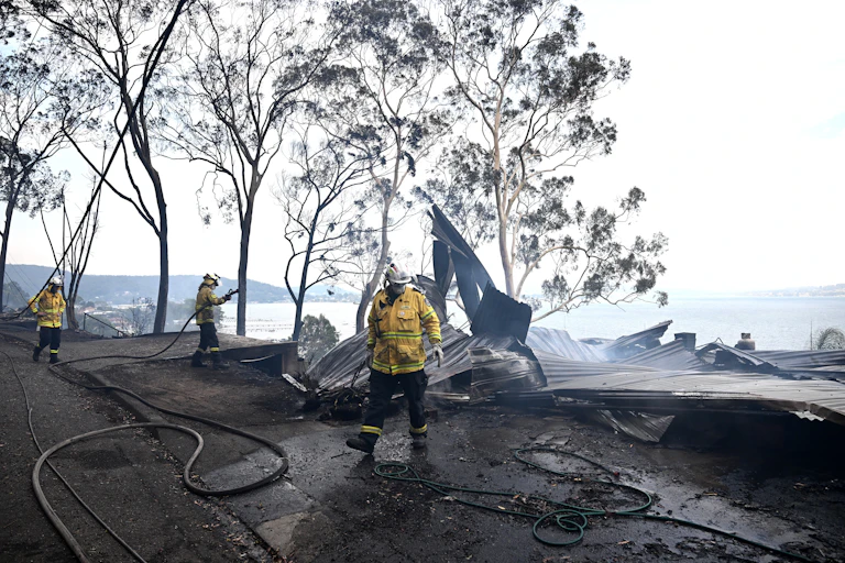 firefighters mopping up after bushfire destroyed house
