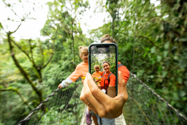 A mother on a treetop walk takes a selfie with her daughter.