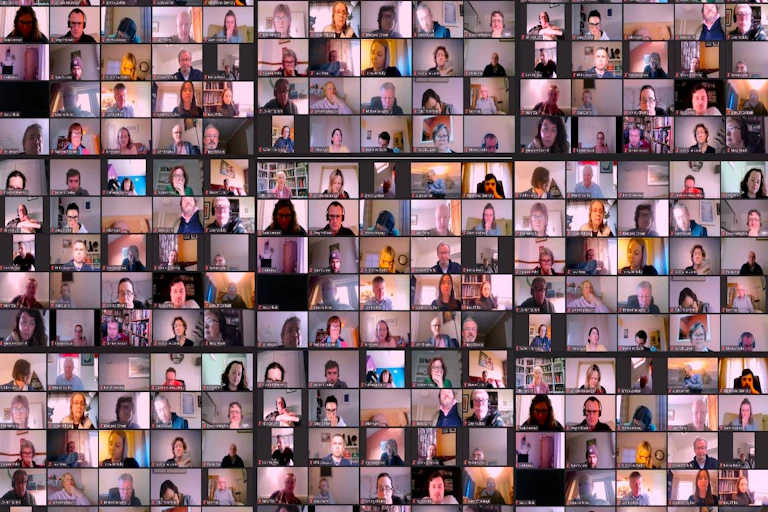 A collage of faces on a large zoom call