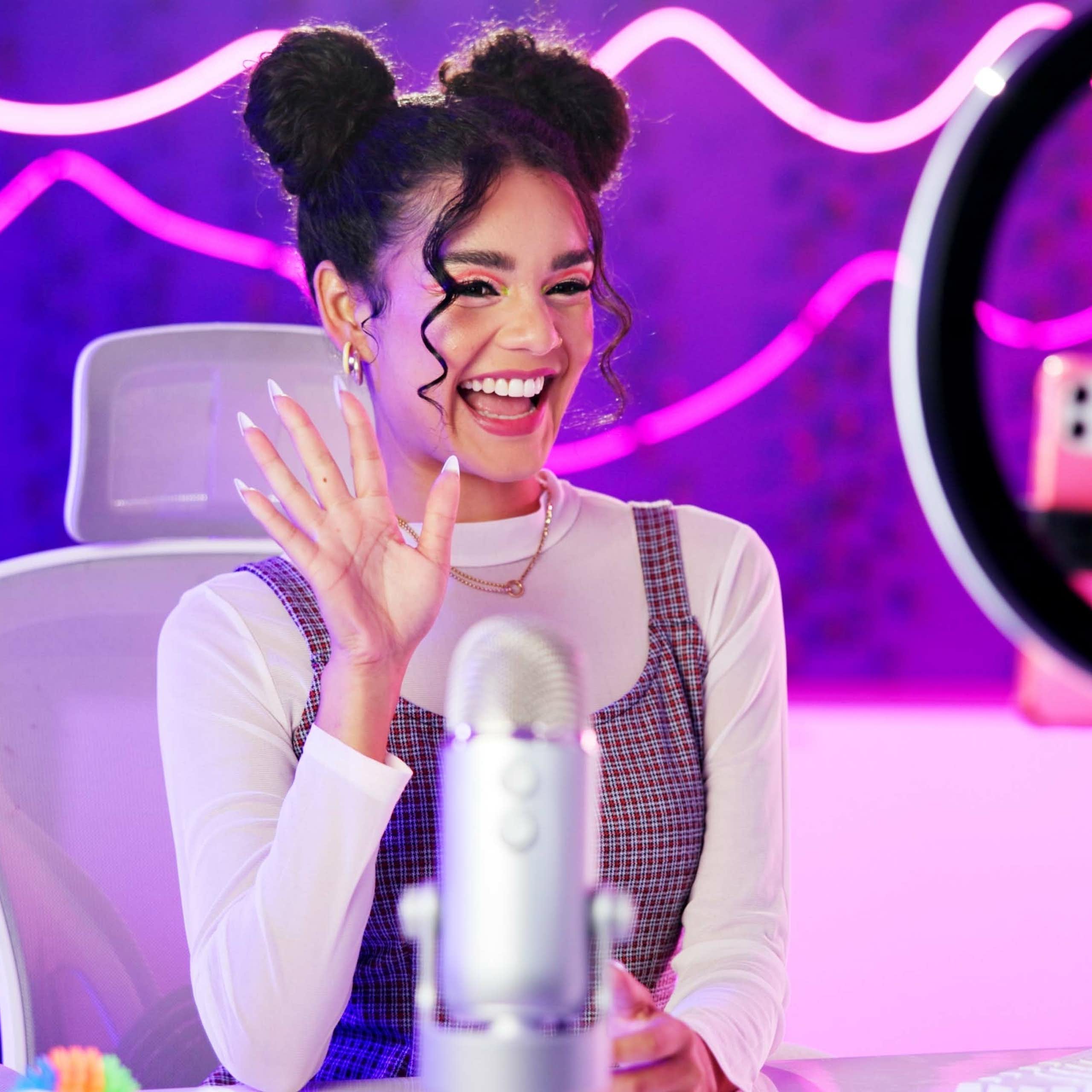 Girl with phone live streaming in neon bedroom for social media audience, fans or followers.