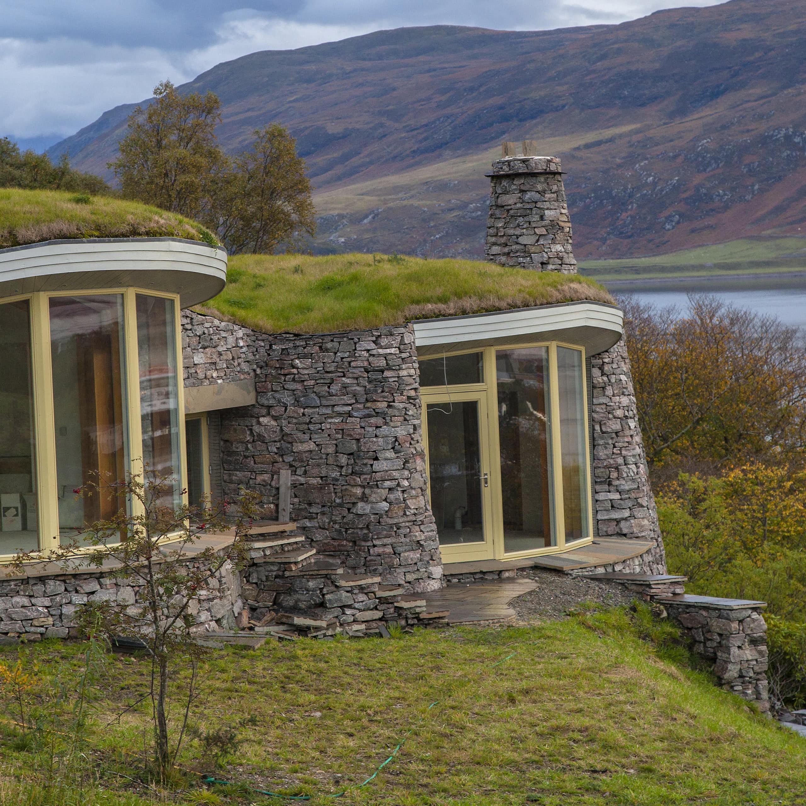 turf covered stone walled homes with loch in background