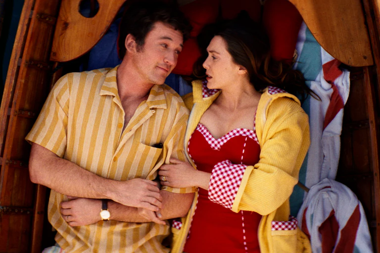 Miles Teller and Elizabeth Olsen lying down in a boat.
